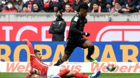 L'attaquant du Bayern Kingsley Coman échappe au tacle du défenseur de Fribourg Manuel Gulde, le 2 avril 2022 à Fribourg   
