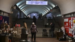 Des personnes vivant dans une station de métro utilisée comme abri anti-bombe se tiennent dans une zone de cuisson à Kharkiv, le 26 mars 2022, pendant l'invasion militaire lancée par la Russie sur l'Ukraine.