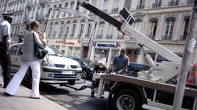 Un véhicule est enlevé par la fourrière à Lyon, en juillet 2006.