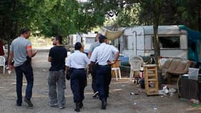 Contrôle policier dans un camp de Roms à Aix-en-Provence. Le gouvernement s'est employé mercredi à défendre son traitement de la minorité Rom, très critiqué, et a fait valoir qu'il ne faisait qu'appliquer la loi en renvoyant chez eux des immigrés sans-pap