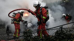Des pompiers intervenant le 1er décembre à Paris, en marge d'une manifestation des gilets jaunes, où des incendies ont été allumés.