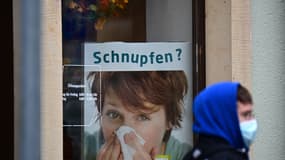 Un homme portant un masque pour se protéger contre le Covid-19 passe devant une pharmacie, en Allemagne, en novembre 2021.