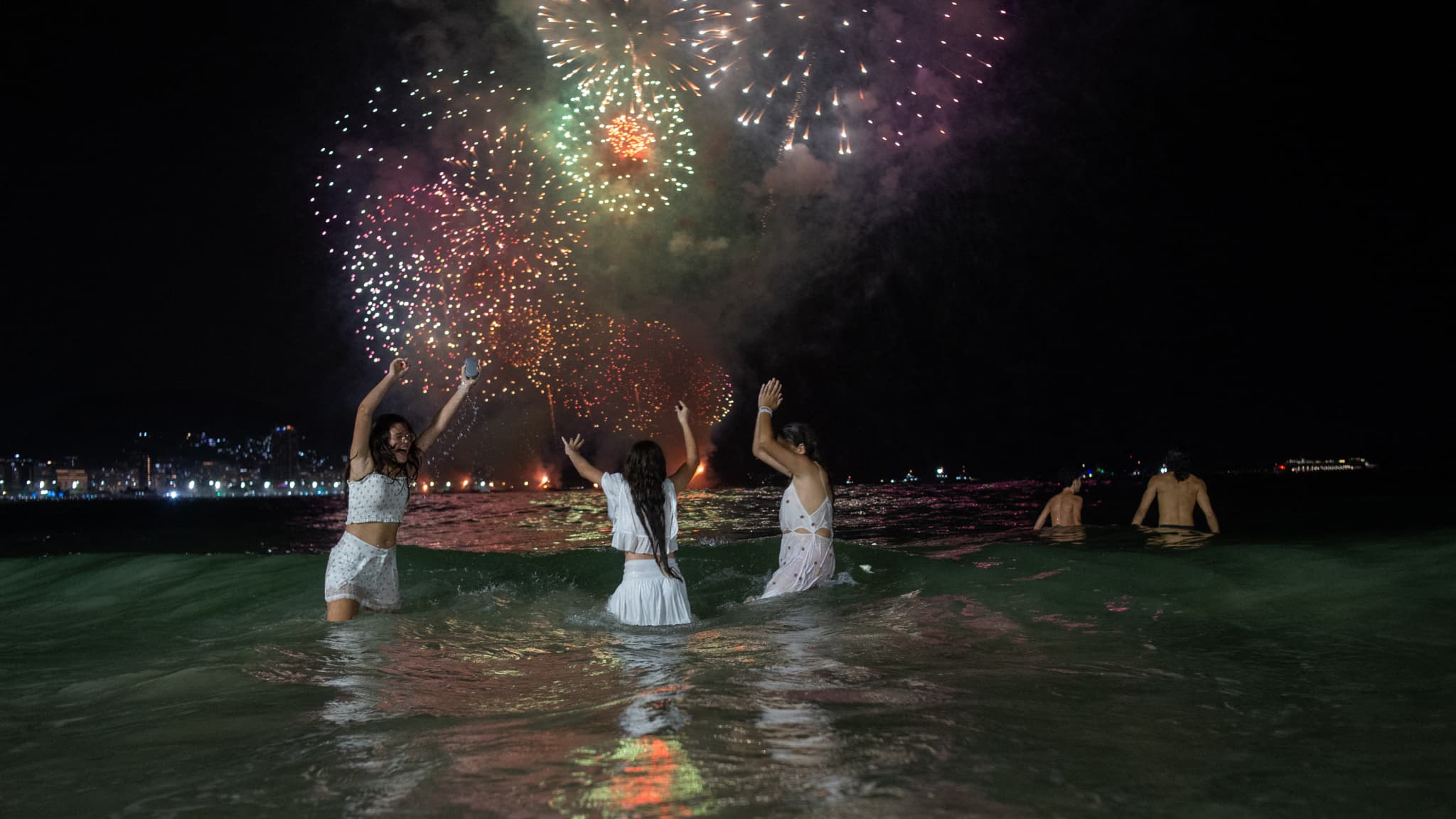 Des personnes célèbrent le traditionnel feu d'artifice du Nouvel An sur la plage de Copacabana à Rio de Janeiro, au Brésil, le 1er janvier 2024.