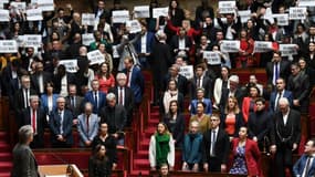 Des députés de la Nupes tiennent des pancartes lors du discours d'Elisabeth Borne confirmant l'utilisation du 49.3 au sujet de la réforme des retraites, à Paris, le 16 mars 2023