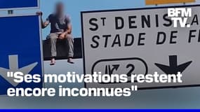 Un homme grimpe sur un panneau de signalisation de l'autoroute A1 