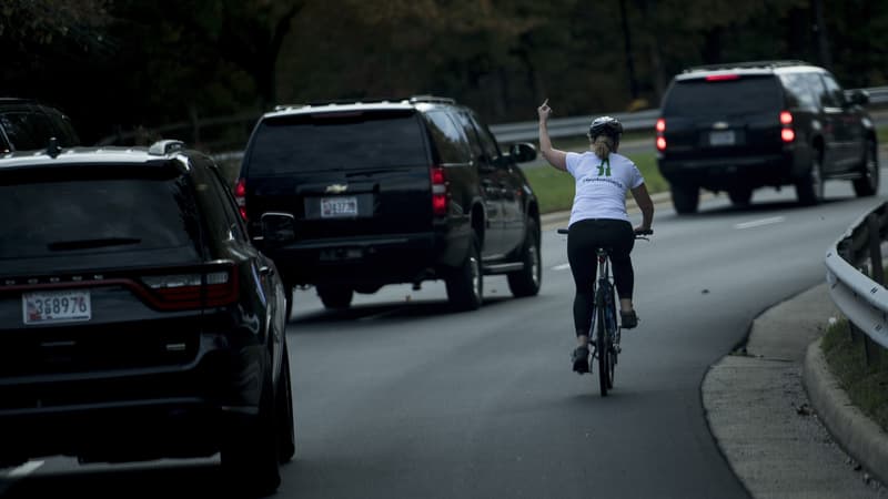 Une femme fait un doigt d'honneur au convoi de Donald Trump, le 28 octobre 2017 à Sterling, en Virginie. 