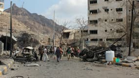 Des hommes armés à Aden près des décombres en janvier 2016, après un attentat à la bombe qui avait eu lieu à proximité de la résidence du chef de la police (Photo d'illustration)