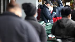 Des New Yorkais patientent avant de pouvoir faire des courses