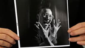 La France, qui recherche le soutien de la Chine pour sa future présidence du G20, n'a salué que du bout des lèvres, vendredi matin, l'attribution du prix Nobel de la Paix à l'opposant chinois Liu Xiaobo (photo de lui tenue par sa femme Liu Xia). /Photo pr