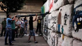 Jeunes Egyptiens tentant de détruire un barrage dans une rue menant au Parlement, près de la place Tahrir au Caire. e bras de fer entre l'armée et les Frères musulmans a connu un nouveau rebondissement mardi en Egypte alors que la Haute Cour constitutionn