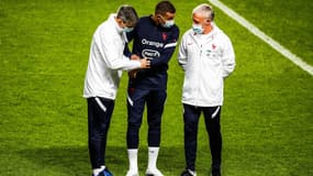 Kylian Mbappé, entouré par le staff de l'équipe de France et Didier Deschamps