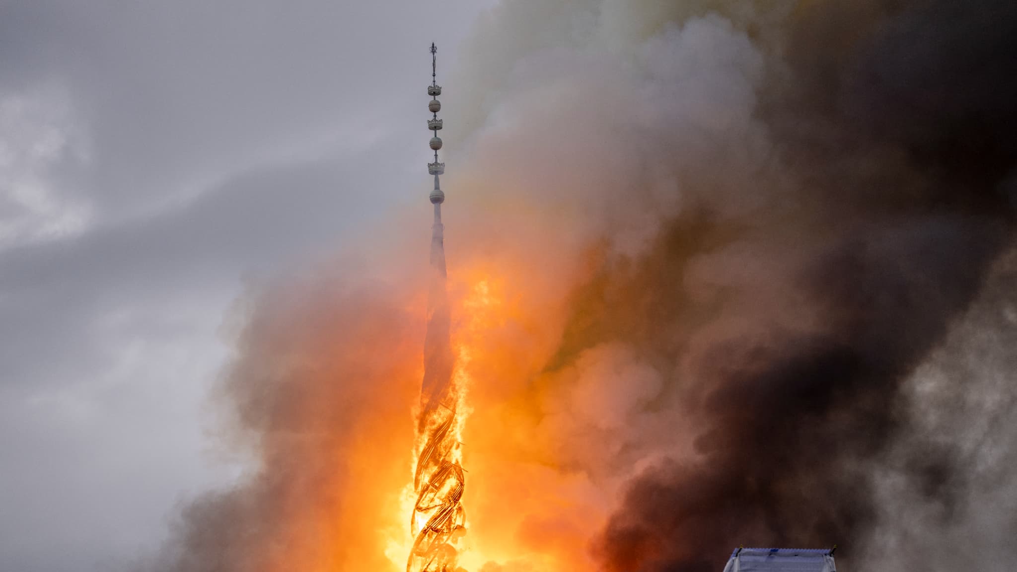 Des panaches de fumée s'échappent de la flèche du dragon du bâtiment de la Bourse en feu dans le centre de Copenhague, au Danemark, le 16 avril 2024.