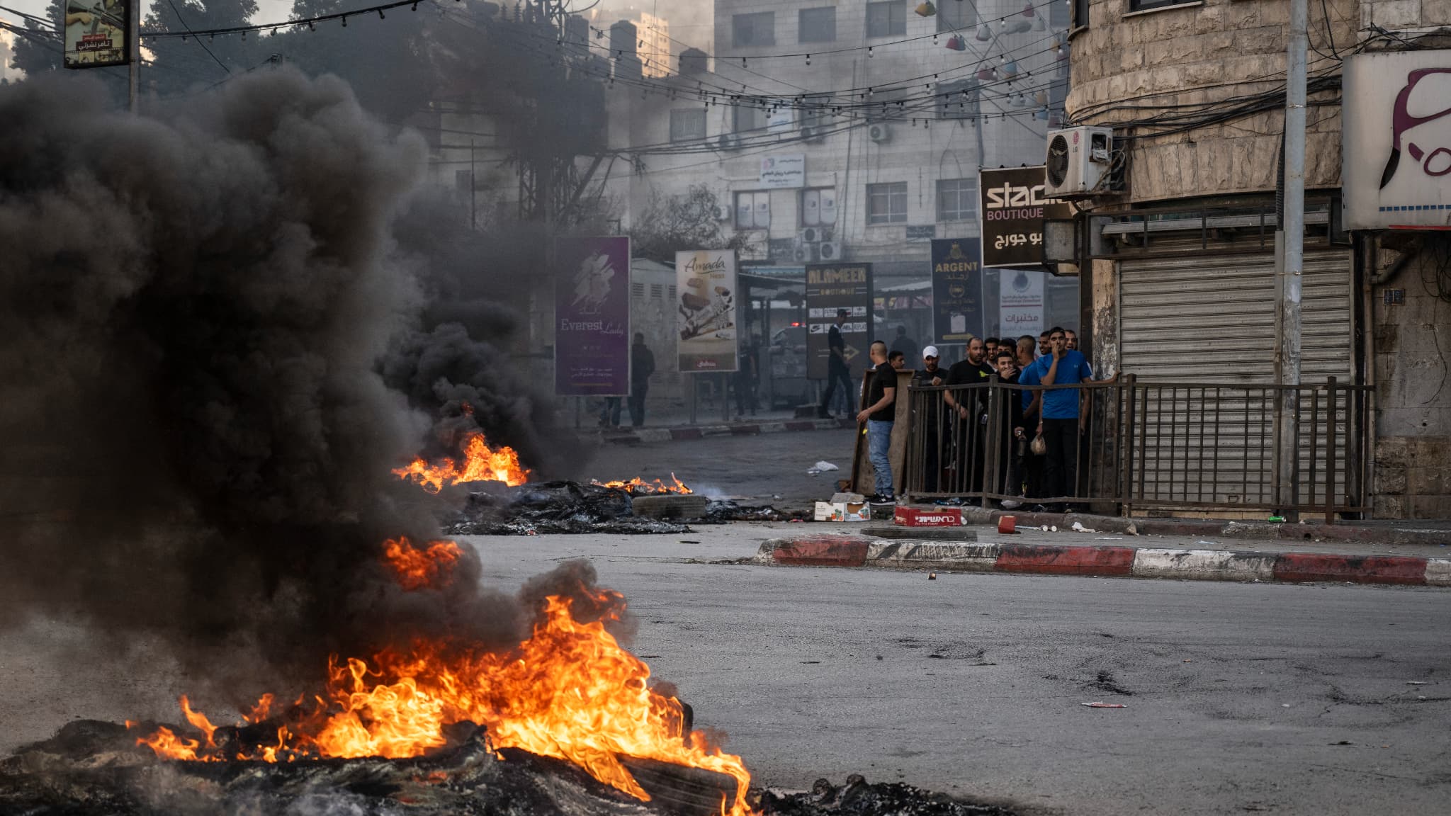 Des jeunes Palestiniens s'abritent derrière un mur lors d'affrontements avec les forces israéliennes dans la ville de Jénine, en Cisjordanie occupée, le 9 novembre 2023.