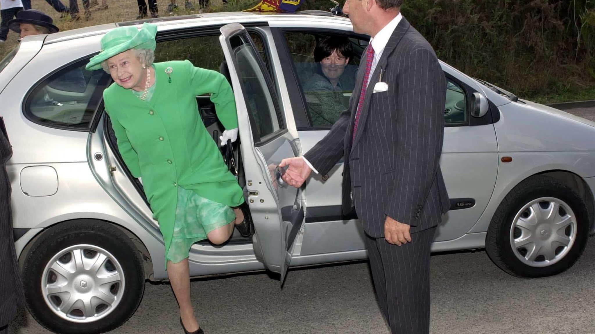 Britain's Queen Elizabeth II struggles to get out of a Renault Scenic used as the Royal Car in Alderney 12 July 2001. The Queen is on a two day visit to the Channel Islands.