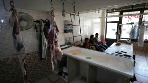 Des Syriens attendent des clients, dans une boucherie vide à Bennich, dans le nord-ouest de la région d'Idleb, en Syrie, le 9 juin 2020