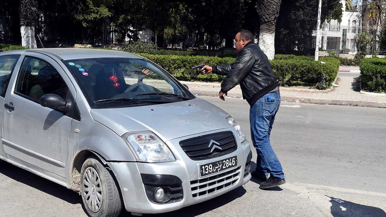 Un policier tunisien en civil arrête un véhicule en le menaçant de son arme à proximité du musée. Un policier tunisien en civil arrête un véhicule en le menaçant de son arme à proximité du musée.