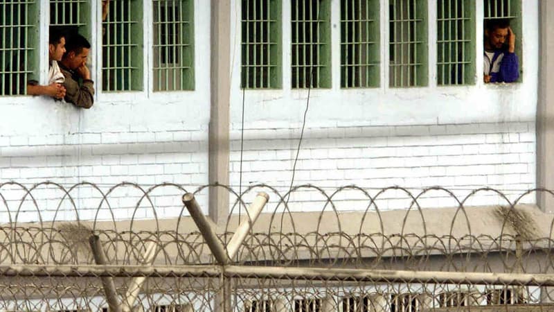 Des détenus de la prison de Bogota à la fenêtre de leur cellule. Image d'illustration.