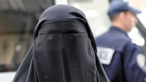 Une femme portant le voile intégral islamique sort d'un poste de police, à Paris. Quatre femmes ont été verbalisées depuis l'entrée en vigueur, il y a une semaine, de la loi qui interdit le port du voile intégral en public. /Photo prise le 11 avril 2011/R