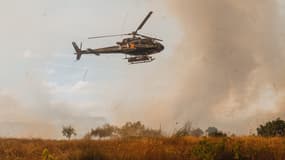 Des brigadiers aériens et des habitants locaux luttent contre un incendie de forêt pour l'empêcher d'atteindre les maisons de Vilela Seca, au Portugal, près de la frontière avec Ourense et la municipalité d'Oimbra, d'où le feu s'est propagé dans le pays voisin, le 19 août 2025. 