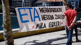 Un homme passe à côté d'une banderole où est écrit "ETA avec le peuple, le peuple avec vous. Merci", dans le village de Pasajes en Espagne, le 9 avril 2017. 