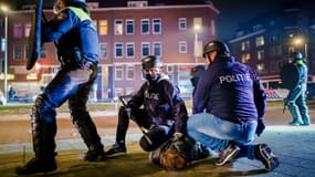 La police interpellant un manifestant à Rotterdam lundi soir. 