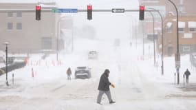 Un homme marche dans le blizzard à Sioux City, alors qu'une tempête de neige frappe l'Iowa, aux États-Unis, le 12 janvier 2024