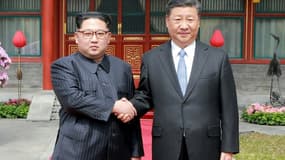 Photo fournie le 27 mars 2018 par l'agence nord-coréenne Kcna du leader nord-coréen Kim Jong-Un (g) et du président chinois Xi Jinping à Pékin