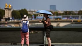Des passants se protégeant du soleil à Paris le 30 juillet 2024. (Photo d'illustration)