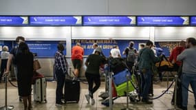 Queue devant le comptoir d'information de la SAA (South African Airways) à l'aéroport international O.R. Tambo à Johannesburg, le 15 novembre 2019