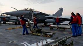 Préparation d'un Rafale à bord du porte-avions Charles-de-Gaulle. Un avion français a détruit dans la nuit de jeudi à vendredi une batterie d'artillerie des forces de Mouammar Kadhafi en Libye, où les forces françaises ont attaqué des installations majeur