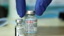 Un médecin dépose sur une table deux flacons des vaccins contre le coronavirus de Moderna et de Pfizer, avant d'en administrer des doses, le 10 août 2021 à Jérusalem.