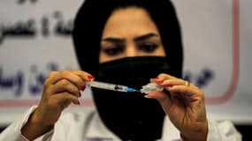 Une médecin prépare une dose de vaccin Pfizer-BioNTech contre le Covid-19 dans un centre de vaccination ouvert dans un centre commercial à Bagdad, le 25 août 2021