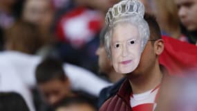 Un supporter porte un masque à l'effigie de la reine Elizabeth II. 