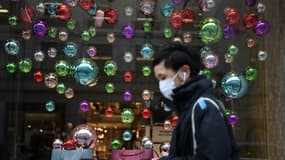 Image d'illustration - Un client masqué devant une vitrine de magasin