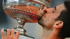 Le Serbe Novak Djokovic embrasse son trophée après sa victoire en finale contre le Grec Stefanos Tsitsipas, à Roland-Garros, le 13 juin 2021