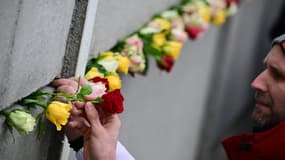 Un homme place une fleur au Mémorial du mur de Berlin, le 9 novembre 2024