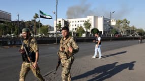 Les forces de sécurité syriennes montent la garde devant le complexe du siège de l'armée syrienne et du ministère de la Défense, gravement endommagé, à Damas, après les frappes israéliennes du 16 juillet 2025. 