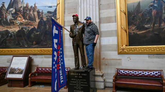 Un partisan de Donald Trump a placé un drapeau en faveur du président sortant sur une statue de la rotonde du Capitole, le 06 janvier 2021