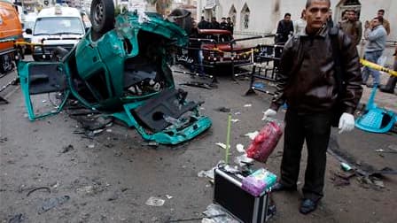 Un policier égyptien devant l'église copte d'Alexandrie cible d'un attentat à la bombe dans la nuit de vendredi à samedi. L'attaque a fait au moins 21 morts et 97 blessés, selon les autorités égyptiennes. /Photo prise le 1er janvier 2011/REUTERS/Amr Abdal