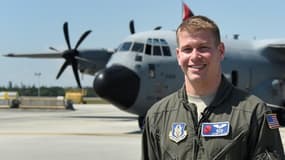 Garrett Black, météorologue de l'armée américaine, pose devant son avion de reconnaisance Hurricane Hunter WC-130 à Miami le 12 mai 2017