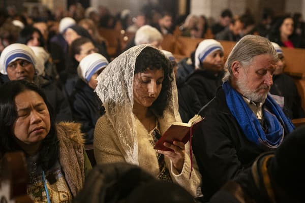 Cette photo prise le 24 décembre 2023 montre des fidèles assistant à la messe de minuit de Noël à l'église de la Nativité dans la ville biblique de Bethléem en Cisjordanie occupée.

