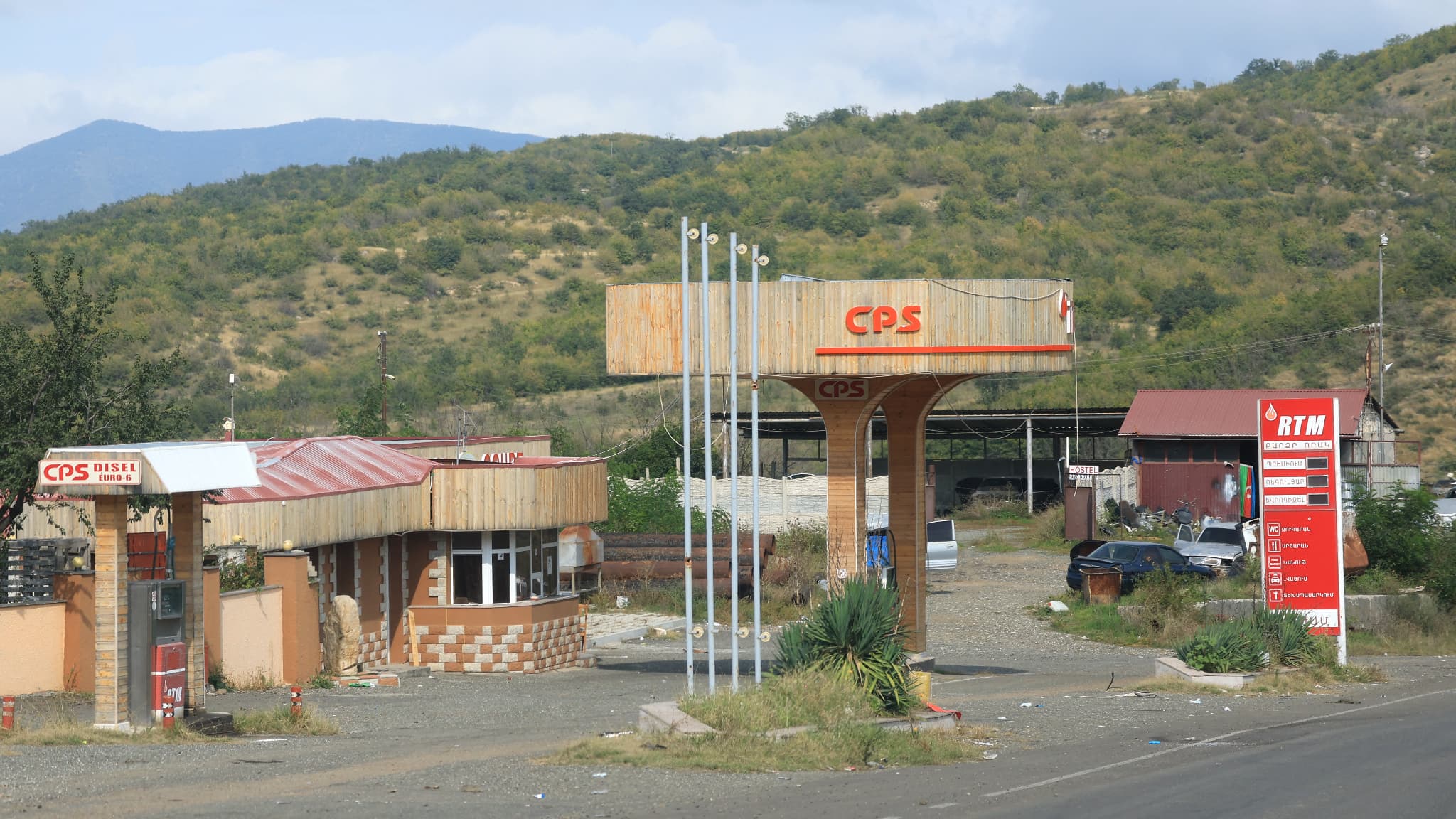 Des épaves de véhicules abandonnés sont garées sur le parvis d'une station-service endommagée et fermée dans la ville de Stepanakert, le 2 octobre 2023. Des épaves de véhicules abandonnés sont garées sur le parvis d'une station-service endommagée et fermée dans la ville de Stepanakert, le 2 octobre 2023.