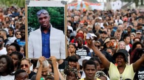 Des manifestants lèvent un portrait d'Adama Traoré en son hommage, en juillet 2018 à Beaumont-sur-Oise. - - FRANCOIS GUILLOT / AFP