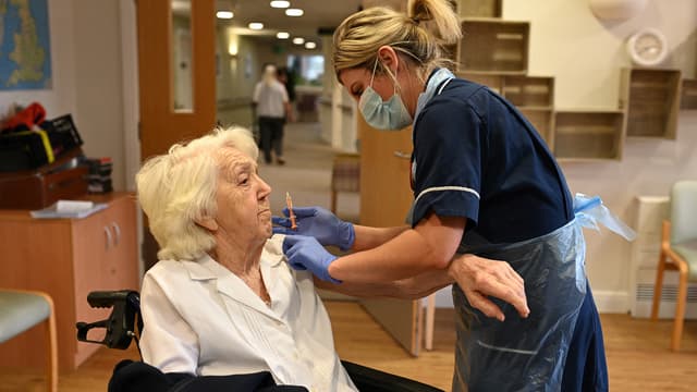 Une résidente de maison de retraite reçoit une dose de vaccin à Wigan, au Royaume-Uni, le 21 janvier 2021