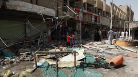 Après un attentat à la voiture piégée à Bagdad, le 24 juillet. Le mois de juillet, au cours duquel 325 personnes sont mortes en Irak, a été le plus meurtrier dans le pays depuis deux ans. /Photo prise le 24 juillet 2012/REUTERS/Hayder Khadim
