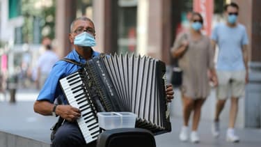 Un joueur d'accordéon porte un masque dans une rue d'Antwerp, en Belgique, le 6 août 2020.