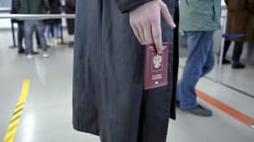 Un réfugié russe tient son passeport à la frontière entre la Russie et la Finlande le 25 septembre 2022.