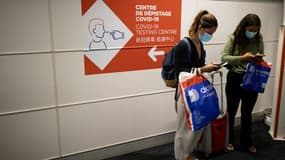 Des passagers à côté d'un point de contrôle sanitaire à l'aéroport Roissy Charles de Gaulle, près de Paris, le 25 avril 2021