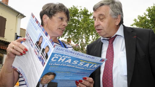 En campagne, Roland Chassain discute avec une sympathisante sur un marché.