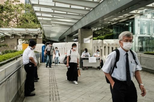 Des habitants de Hong Kong déambulent le 3 juin 2020 près de barricades dressées par les autorités locales en réponse aux manifestations pro-démocratie. Des habitants de Hong Kong déambulent le 3 juin 2020 près de barricades dressées par les autorités locales en réponse aux manifestations pro-démocratie.